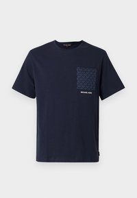 Μπλε βαμβακερό T-shirt σε ναυτικό μπλε χρώμα με τσέπη με σχέδιο που φέρει τα αρχικά «MK» και λευκό λογότυπο. Κοντά μανίκια και στρογγυλή λαιμόκοψη.