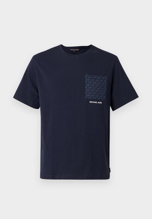 Μπλε βαμβακερό T-shirt σε ναυτικό μπλε χρώμα με τσέπη με σχέδιο που φέρει τα αρχικά «MK» και λευκό λογότυπο. Κοντά μανίκια και στρογγυλή λαιμόκοψη.