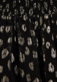 Fekete anyag fémes arany leopárd foltokkal, ráncolt derékpánttal és strukturált felülettel.