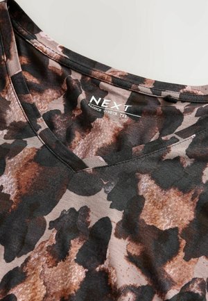 Camiseta de cuello en V en una mezcla de tonos marrones terrosos y negros, con un diseño de estampado animal moderno y una textura de tela suave.