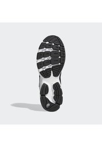 Sola de sapato atlético em preto e branco com uma superfície de borracha texturizada, apresentando múltiplos padrões de tração e elementos de design circulares.