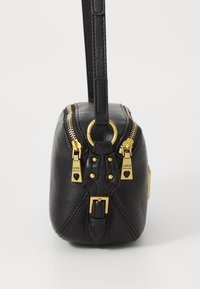 Borsa a mano in pelle nera con doppie cerniere dorate, finiture in hardware dorato e un design distintivo della fibbia alla base. Finitura strutturata.
