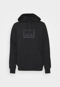 Haut à capuche noir en coton doux, avec une poche kangourou à l'avant, un cordon de serrage pour la capuche et un patch logo noir mat sur la poitrine.
