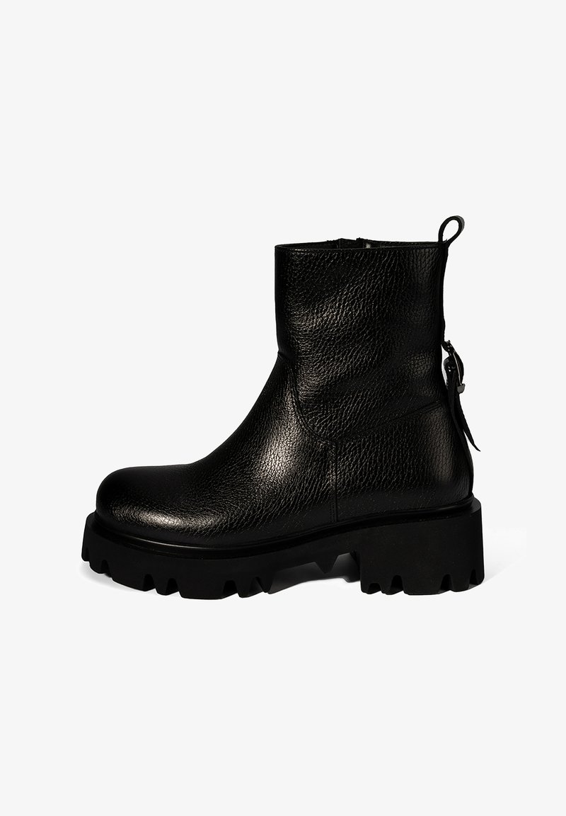 Bottines noires en cuir texturé, dotées d'une semelle crantée épaisse et d'une fermeture éclair avec un tirant à l'arrière.