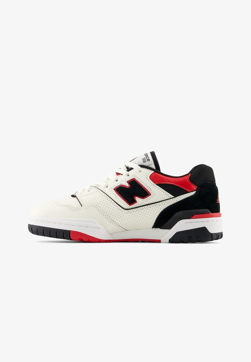 White sneaker with black and red accents, textured leather, perforated design, round toe, and rubber outsole featuring a contrasting tread.