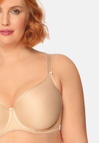 Beżowy biustonosz z fiszbinami o gładkiej, matowej fakturze; regulowane ramiączka; subtelne detale w szwie; formowane miseczki dla lepszego kształtu.