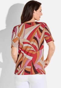 Kurzarmoberteil mit einem bunten abstrakten Muster in Rottönen, Rosa, Braun und Cremetönen. Aus dehnbarem Stoff mit bequemer Passform gefertigt.