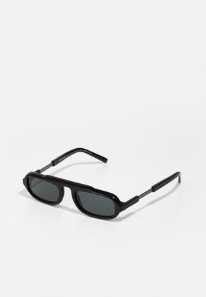Schwarze Sonnenbrille mit kantigen Rahmen, dunklen Gläsern und metallischen Bügeln mit eingravierten Details. Glattes, glänzendes Finish mit einem auffälligen Design.