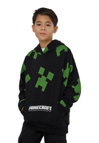 Felpa nera con cappuccio caratterizzata da motivi grafici pixelati verdi, dotata di tasca frontale a marsupio e logo "Minecraft" presentato sull'orlo.