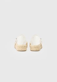 Hvide canvas espadriller med en vævet jute sål. Har et rundet design og en justerbar sølv spænde på siden.