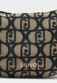 Must mustri mustri beezis kangaste peal on kuldne "LIU·JO" brändi detail. Sile tekstuur, ümar kuju ja tõmbluku sulgemine.