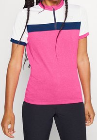 Růžový atletický top s krátkými rukávy, s bílým a námořnicky modrým vodorovným pruhem přes hrudník, s čtvrtinovým zipem u výstřihu a prodyšným materiálem.