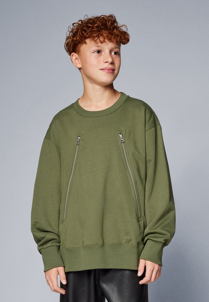 Sudadera de color verde oliva con escote redondo, mangas largas y dos bolsillos verticales con cremallera en la parte delantera. Textura de tela suave.