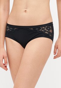 Black bikini bottoms with a mid-rise design. Includes lace detailing at the waistband, featuring a floral pattern and scalloped edges.