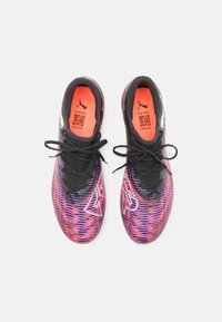 Puma-lenkkarit, joissa on liukuvärjäys violetin ja oranssin sävyissä, mustat teksturoidut nauhat ja suuri valkoinen logo sivussa.