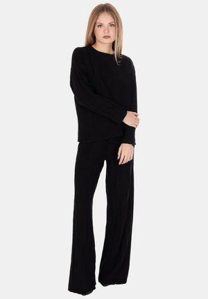 Set per il tempo libero in maglia a coste nera, composto da una maglietta a maniche lunghe e pantaloni a gamba larga. La texture è morbida, con una vestibilità comoda e sottili righe verticali.