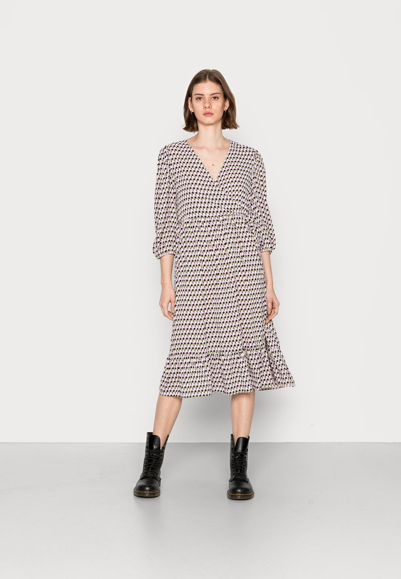 Vestido midi com estampado floral, decote em V, cintura elástica, mangas bufantes de três quartos e barra com babados. Usado com botas pretas de atacador.