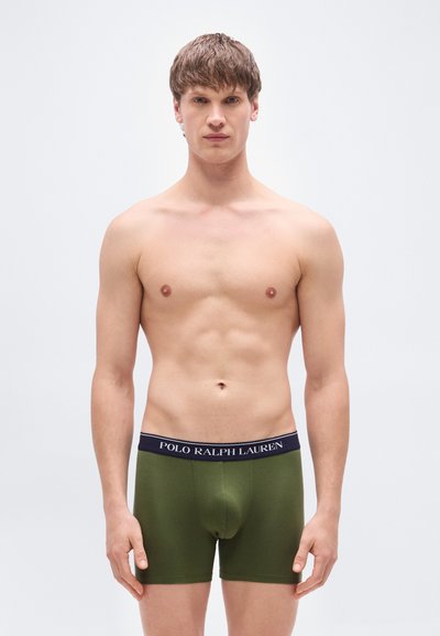 Εσωρουχά boxer σε ελιά πράσινο με ζώνη μέσης σε ν αυτικό μπλε που φέρει το λογότυπο "POLO RALPH LAUREN". Κατασκευασμένα από απαλό, ελαστικό υλικό.