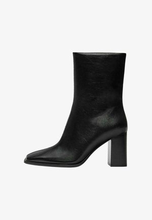 Stivale nero alla caviglia realizzato in pelle liscia, con punta affusolata e tacco quadrato spesso. Design minimalista senza decorazioni.