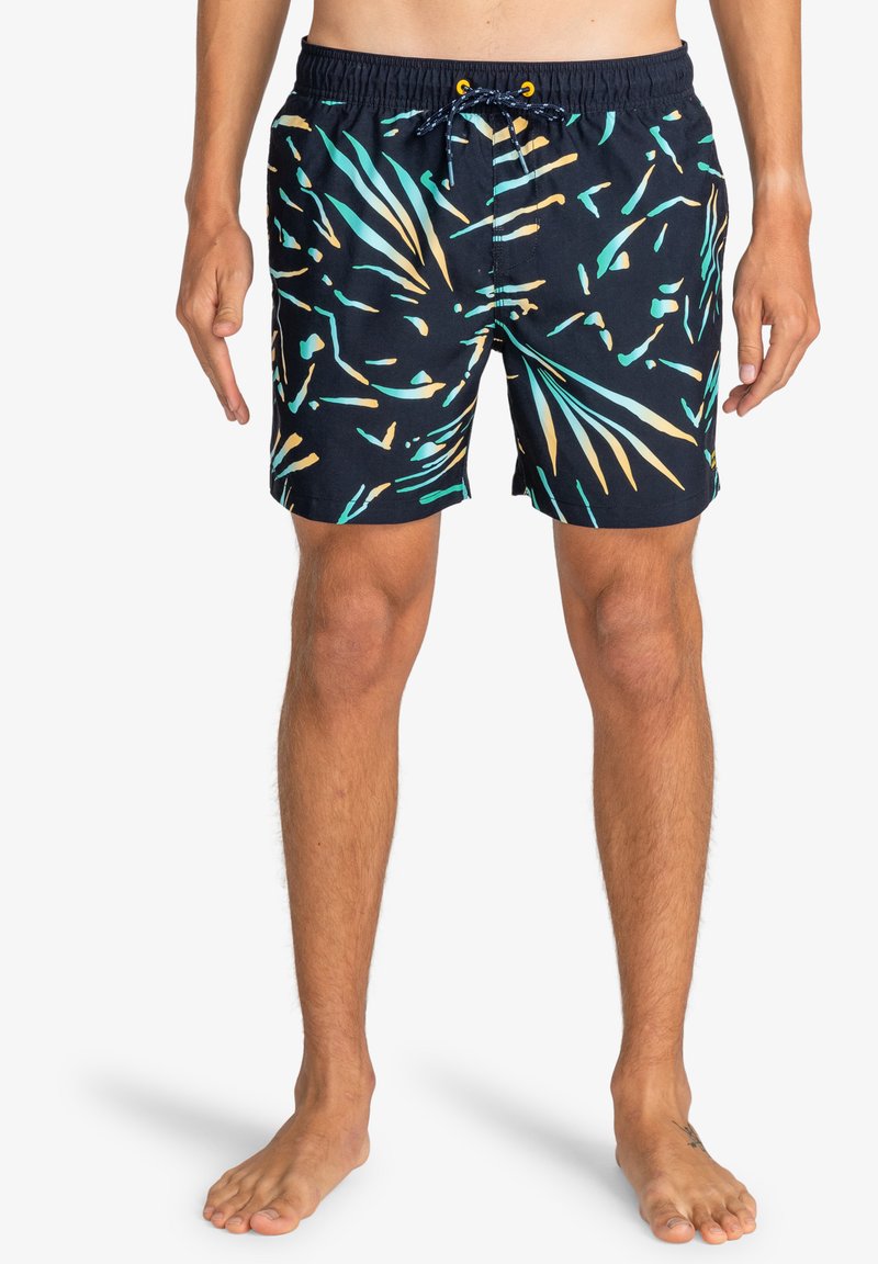 Costumi da bagno su uno sfondo scuro con motivi astratti verdi, gialli e blu; presentano una vita elasticizzata e dettagli con cordino.