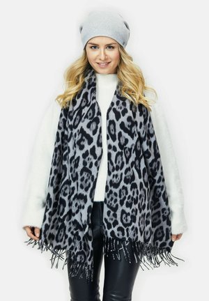 Gray leopard print scarf with fringed edges, made of soft material; paired with a light gray knit beanie and a white sweater.