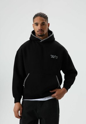Zwarte hoodie met een zak aan de voorkant met ritssluiting, contrasterende stiksels op de capuchon en een geborduurd logo op de borst.