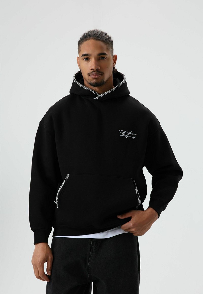 Zwarte hoodie met een zak aan de voorkant met ritssluiting, contrasterende stiksels op de capuchon en een geborduurd logo op de borst.