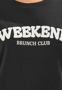 Felpa nera con la scritta "WEEKEND BRUNCH CLUB" in bianco, con tessuto soffice per le lettere e scollatura rotonda.