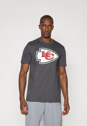 T-shirt en coton gris avec un grand logo des Kansas City Chiefs en blanc et rouge, dans une forme stylisée sur le devant. Manches courtes, col rond.