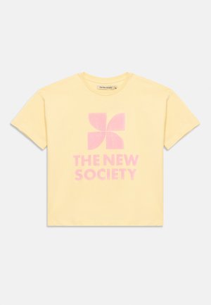 Žuta majica kratkih rukava s ružičastim stiliziranim logotipom vjetrenjače i tekstom "THE NEW SOCIETY" u sredini sprijeda.