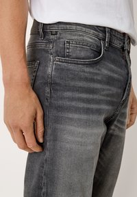 Grau denim Jeans mit slim Fit, subtiler Waschung, Fünf-Taschen-Design und einem schwarzen Logo-Tag am Bund. Leicht ausgewaschene Textur.