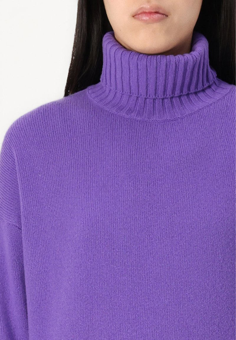 Lila Rollkragenpullover aus weichem Strickmaterial, mit einem gerippten Kragen und lockerer Passform, einer glatten Textur und gleichmäßiger Farbe.