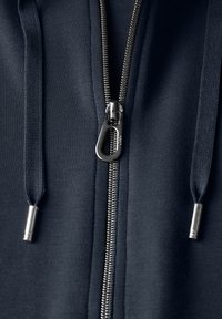 Giacca a zip blu navy con zip in metallo argentato, tessuto texturizzato e cordini coordinati con terminali in metallo sul davanti.