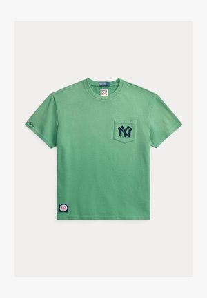 Grønn bomulls t-skjorte med rund hals, korte ermer, en lomme foran, og marineblå brodert logo på lommen og ermet.