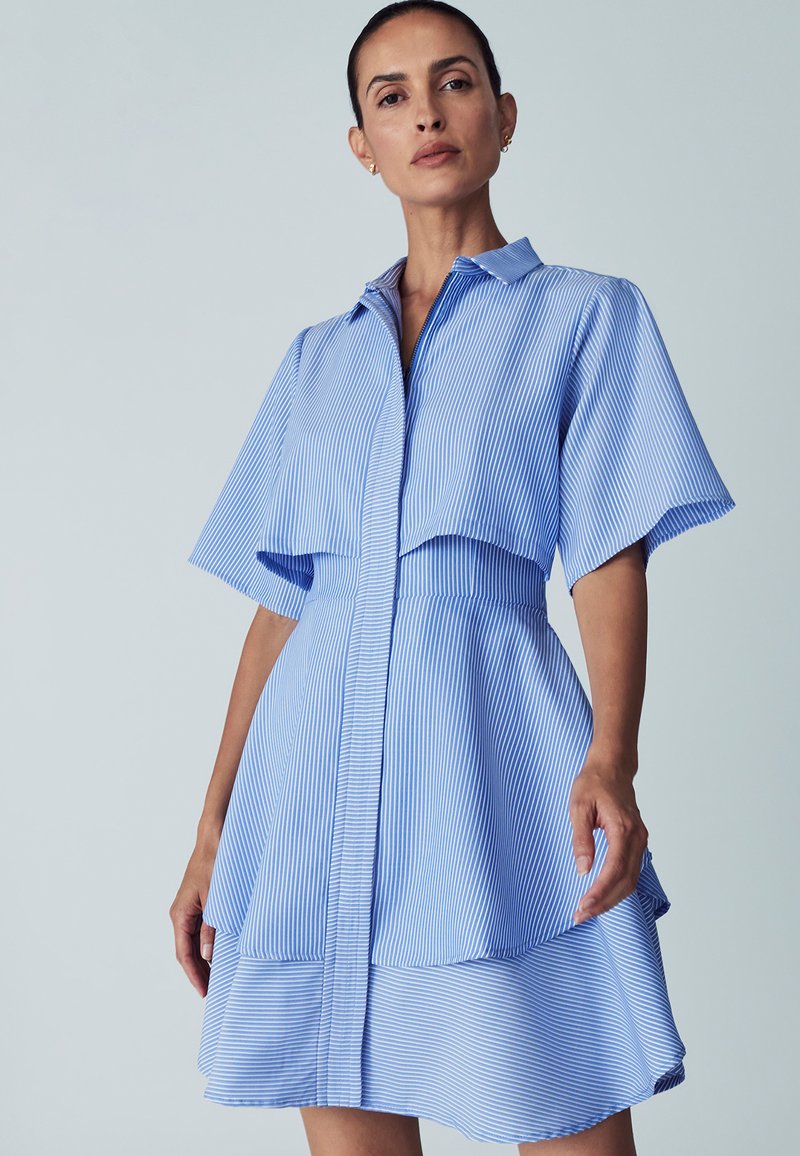 Gestreiftes Hemdkleid in Blau und Weiß mit kurzen, schwingenden Ärmeln, einer durchgehenden Knopfleiste und einem gestuften Rock. Glattes Material mit taillierter Passform.