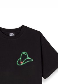 Camiseta de algodón negra con un bordado en verde y rojo de un sombrero de vaquero en el área del pecho izquierdo. Diseño de manga corta y cuello redondo.
