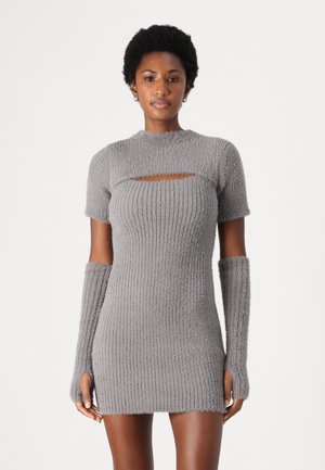Robe en maille ribbed grise avec des manches courtes, un col rond et une découpe centrale. De longs manchons en maille s'étendent des manches.