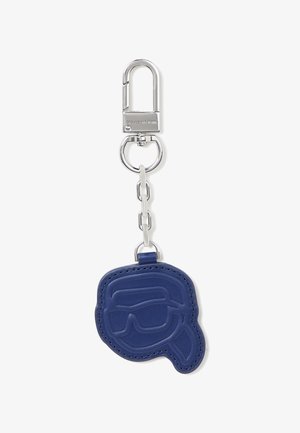 Llavero de metal plateado con cadena unida a un adorno de cuero azul con forma y grabado de una cara que lleva gafas de sol y una coleta.