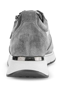 Grijze suede sneaker met een laag profiel ontwerp, voorzien van een reflecterende metalen strip op de hiel en een gestructureerde zwarte rubberen zool.