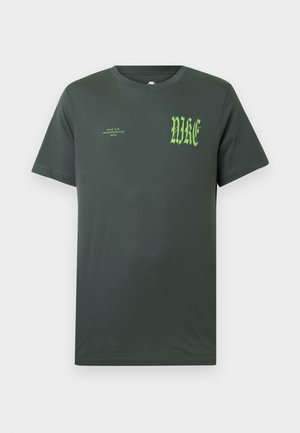 Dark green cotton t-shirt with short sleeves. Front features large green "NIKE" logo and smaller text, classic crew neckline, smooth texture.