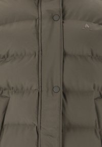 Dunkelolivgrüne Pufferjacke mit Reißverschluss, Druckknöpfen, gestepptem Design und kleinem Logo auf der oberen linken Seite.