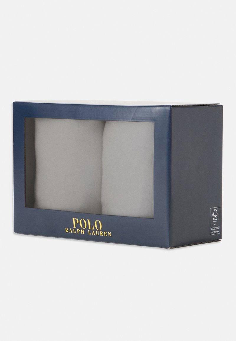 Caixa de presente Polo Ralph Lauren em azul marinho, com uma janela transparente exibindo dois itens cinzentos dentro, e com a marca dourada na parte frontal.