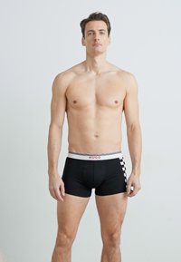Boxeri negri pentru bărbați, cu o curea albă pe care este inscripționat logo-ul 'HUGO', și un accent cu model carourile pe lateral. Fabricat dintr-un material flexibil.