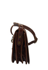 Sac à main en cuir marron avec une forme structurée, doté d'une bandoulière et de coutures accentuées. Trois compartiments visibles sur le côté.