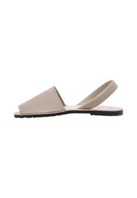 Sandalia tipo slingback de cuero beige con punta abierta, suela plana y diseño minimalista. Presenta una suela de goma para mayor tracción.