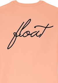 T-shirt color pesca con una grande scritta nera in corsivo "float" sulla schiena. Realizzato in tessuto morbido con un design a girocollo.