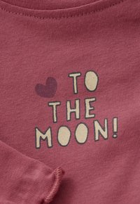 Dunkelrosa Stoff mit geripptem Ausschnitt und aufgedrucktem Text "Bis zum Mond!" sowie einem kleinen Herz-Grafik in Dunkelrosa.