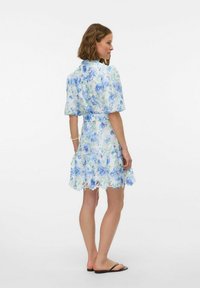 Vestito floreale corto con stampa blu e verde, maniche corte, vita cintrata e bordo svasato con bordi scallop.