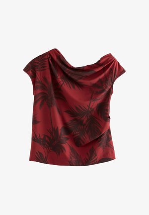 Rode top met een gedrapeerde halslijn, korte mouwen en een zwart palmenbladpatroon op een gestructureerde stof. Asymmetrische zoomlijn.