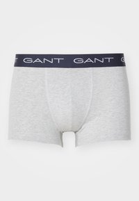 Boxers de algodón gris con una cinturilla azul marino que presenta el nombre de la marca "GANT" en letras blancas. Diseño simple y ajustado sin patrones.